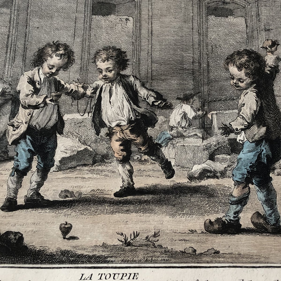 Grafika ukazująca osiemnastowieczną scenę. Trzej chłopcy podczas zabawy bączkiem. Ubrani w jasne koszule, surduty i krótkie spodenki wiązane pod kolanem. Kolorystyka w czerni i beżu, spodenki chłopców akwarelowo podmalowane są na niebiesko i czerwono. Na dole grafiki napis La Toupie.