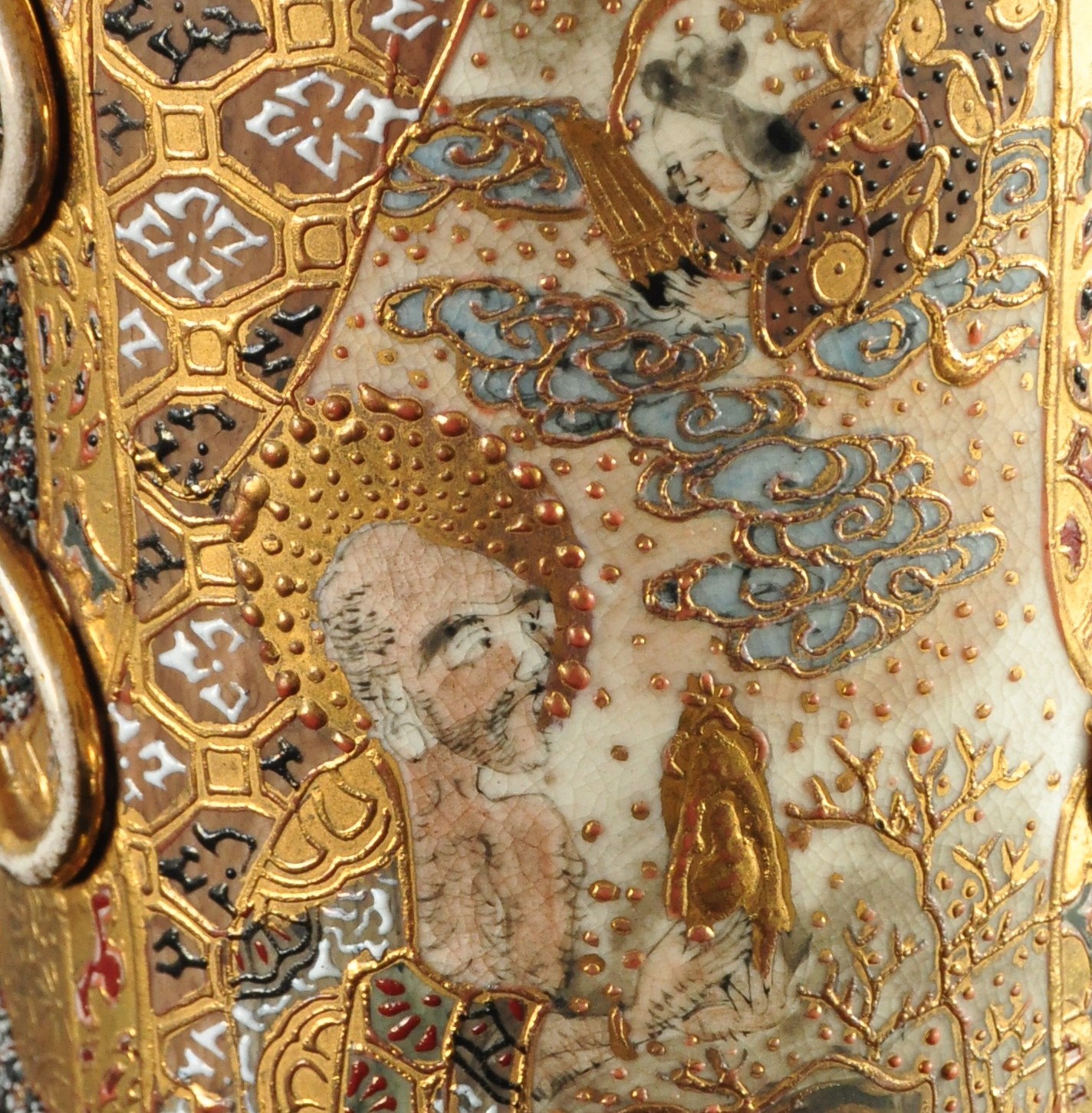 1. Fragment dekoracji korpusu lampy, scena z japońskiej legendy o miłości Orihime i Hikoboshi; nr inw. MPK/CS/2050 Na ceramicznym korpusie lampy naftowej bogato dekorowana złoceniami przestrzeń. W polu scena ukazująca klęczącego mężczyznę trzymającego złoty przedmiot w dłoni, nad nim z chmur wyłania się pochylona w jego kierunku w popiersiu postać kobieca.