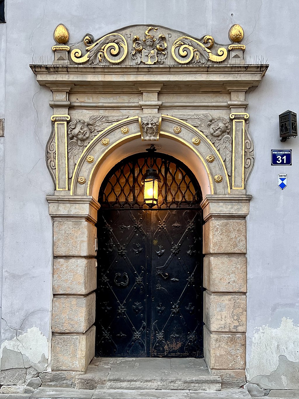 Portal Kamienicy pod św. Anną, Rynek Starego Miasta 31, Warszawa, 2022 r. https://commons.wikimedia.org/wiki/File:Portal_at_Kamienica_pod_%C5%9Bw._Ann%C4%85,_Old_Town_in_Warsaw,_2022.jpg?uselang=pl Kolorowe zdjęcie portalu bramnego Kamienicy pod św. Anną pochodzące z roku 2022