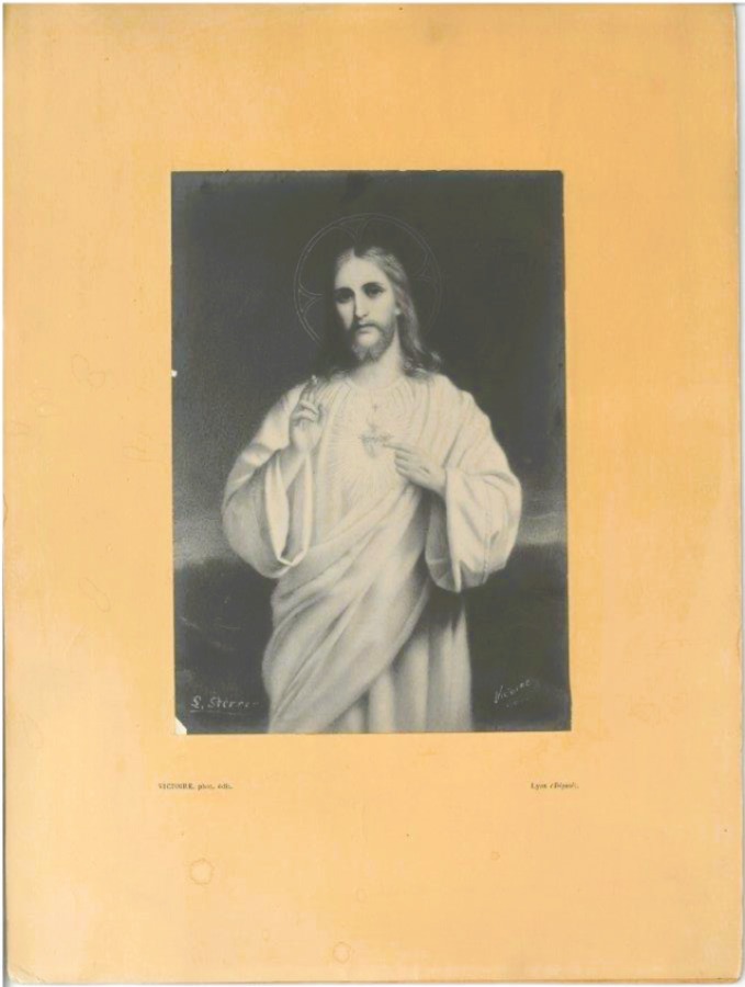 Obrazek religijny „Najświętsze Serce Jezusa”; nr inw. MPK/A/255 Fotografia współczesna przedstawiająca obrazek religijny z wizerunkiem Jezusa Chrystusa, naklejony na karton. Jezus ukazany jest w ujęciu frontalnym, od kolan w górę. Nosi jasne, długie szaty i ma długie włosy oraz brodę. Jego głowa otoczona jest aureolą – cienkim, okrągłym nimbem świetlistym. Twarz Chrystusa jest spokojna i łagodna, a spojrzenie skierowane bezpośrednio na widza. Prawą rękę unosi w geście błogosławieństwa (dwa palce uniesione), natomiast lewą wskazuje na swoje serce – Serce Jezusa – które widoczne jest na piersi, otoczone promieniami, z krzyżem i cierniową koroną. W tle ilustracji nie ma wyraźnych elementów – dominuje ciemna, rozmyta przestrzeń, co uwydatnia postać Chrystusa. Obraz podpisany jest w lewym dolnym rogu sygnaturą „L. Sterre” (niewyraźne), a w prawym rogu podpis „Victorie / Lion”. Cała ilustracja umieszczona jest na beżowym kartonie. Na dole kartonu, drobnym drukiem, widnieje napis: „VICTORIE, phot. édit. / Lyon (Deéposé).