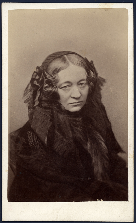 Celestyna z Zamoyskich Działyńska, fotografia, Grzegorz Sachowicz, koniec lat 60. XIX w., MPK/F/1231 Fotografia przedstawia Celestynę z Zamoyskich Działyńską, starszą kobietę o poważnym wyrazie twarzy ujętą w popiersiu. Ubrana jest w czarną suknię oraz czepek z długą chustą. Jej włosy w znaczniej części schowane są pod czepkiem, a po bokach skręcone w loki i spięte spinkami.
