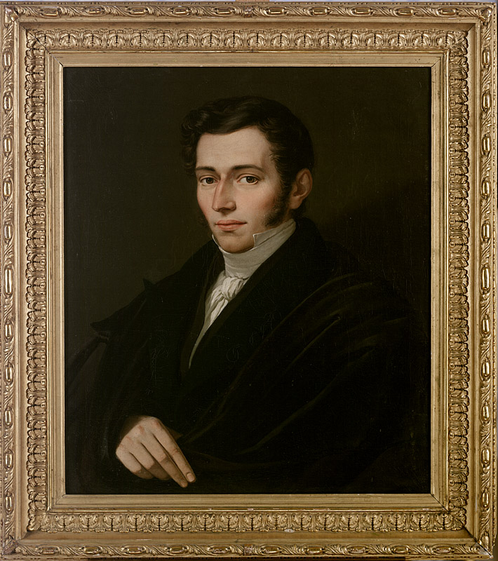 Portret przedstawia młodego mężczyzny w półpostaci, na ciemnym, niemal czarnym tle. Mężczyzna zwrócony jest lekko w lewo, ale patrzy w stronę widza. Ma ciemne, krótko przystrzyżone włosy, jasną cerę i wyraźne bokobrody. Ubrany jest w czarny surdut lub płaszcz, spod którego widoczna jest biała koszula z wysokim kołnierzem i białą chustą pod szyją. Ciemny strój niemal zlewa się z tłem. Jasno oświetlone są przede wszystkim twarz oraz prawa dłoń, którą mężczyzna opiera przed sobą. Obraz utrzymany jest w ciemnej, stonowanej kolorystyce, z kontrastującymi jasnymi partiami twarzy i koszuli. Całość ujęta jest w bogato zdobioną, złoconą ramę z ornamentami roślinnymi i geometrycznymi.